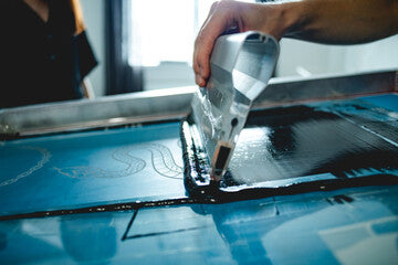 Racle de sérigraphie appliquant  l'encre sur le cadre