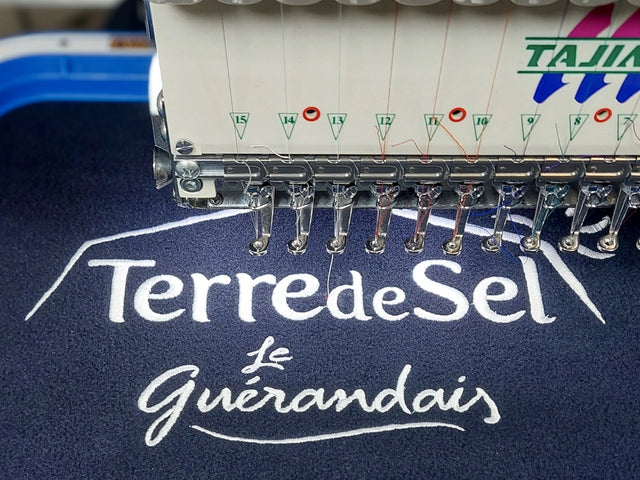 Machine à broder Tajima réalisant la broderie du logo le guérandais sur une polaire